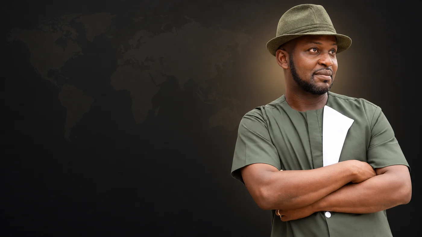 Joseph Opare in an olive hat and even green tunic against a subtle world map